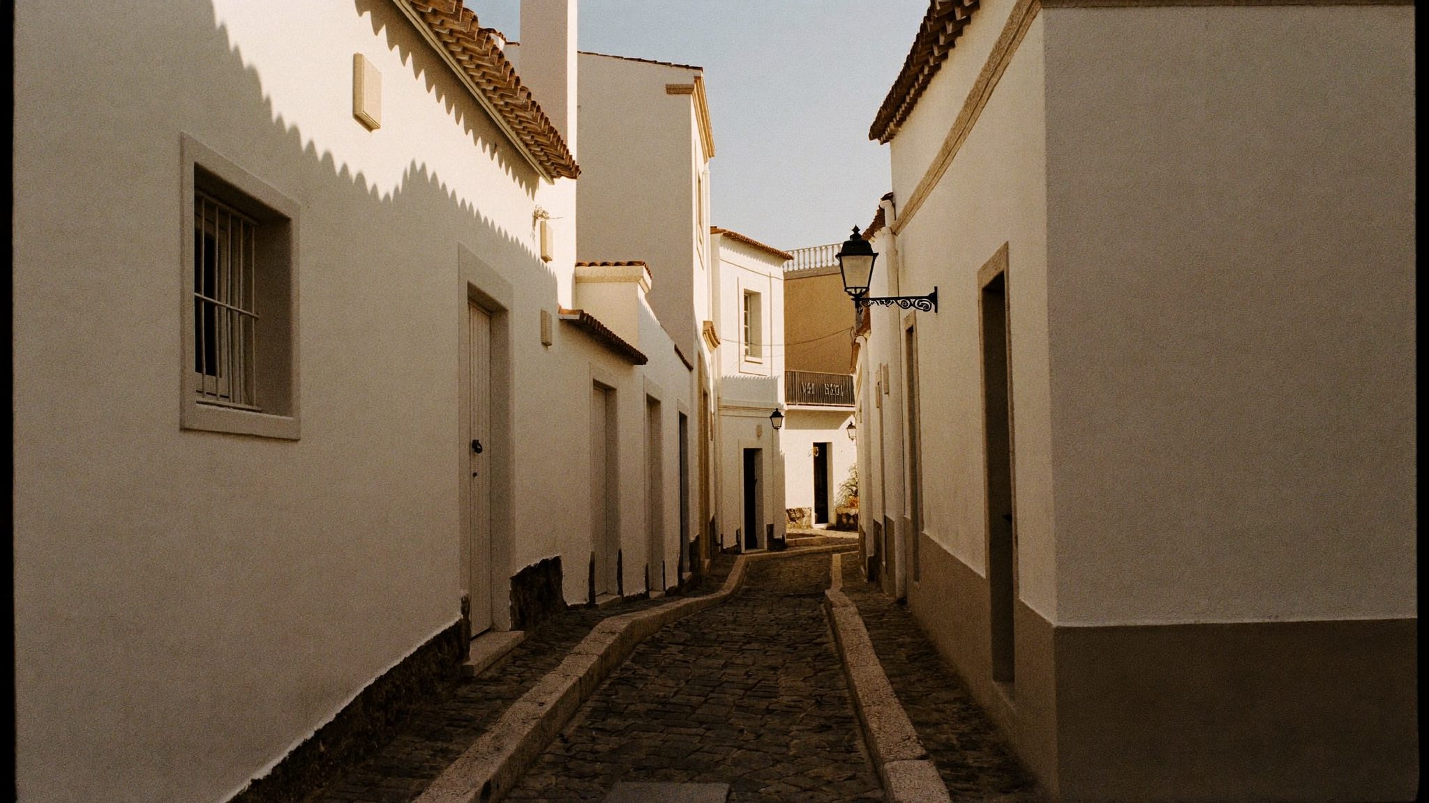 Rua empedrada da zona velha do Funchal ao fim da tarde dourada